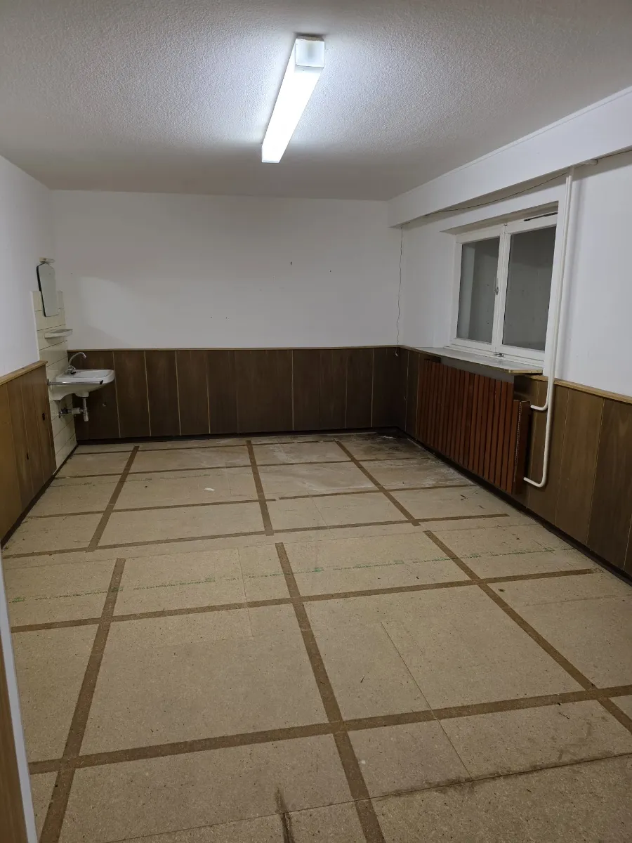 Leerer Kellerraum mit Holzvertäfelung nach der Kellerentrümpelung